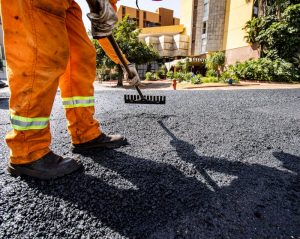 a man working on an asphalt driveway